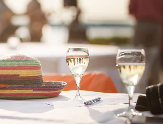 Colorful sunhat and wine on table